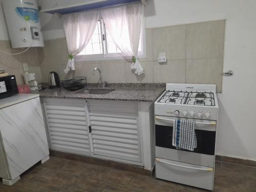 a small kitchen with a stove and a sink at Piscis in San Nicolás de los Arroyos