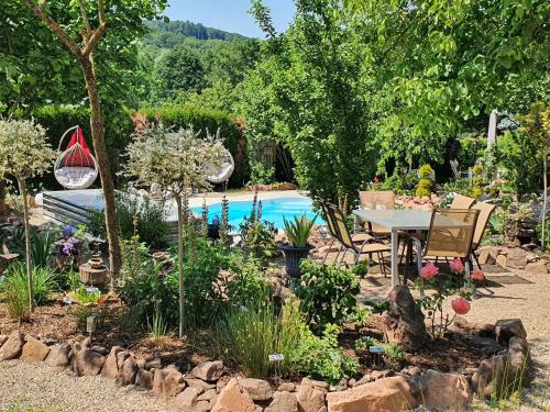a garden with a table and a swimming pool at Ferienwohnung Anke Günther Dach in Bad Kissingen