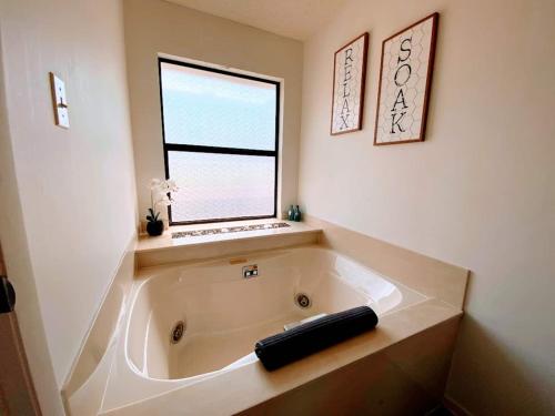 una bañera en un baño con ventana en Serenity Retreat, Escape The City, Nature, Lake, en Briarcliff