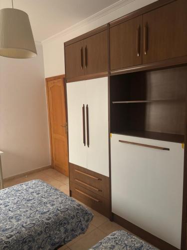 a kitchen with white cabinets and a bed in a room at Copenhagen Lovely in Gran Tarajal