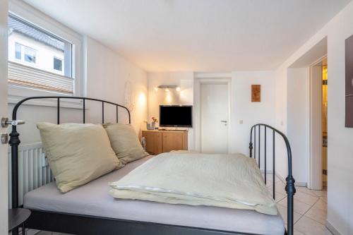 a bedroom with a bed with white sheets and a window at Modernes Apartment am Deister in Springe