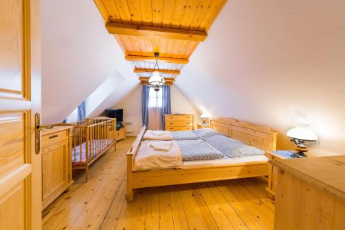a bedroom with a bed with a wooden ceiling at Baďurky in Velké Karlovice