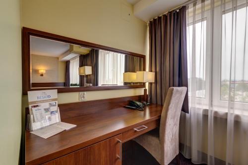a desk in a hotel room with a mirror at Hotel Beskid in Nowy Sącz