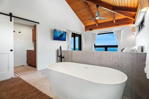 a large white tub in a bathroom with a window at Manu O Ku in Kailua-Kona