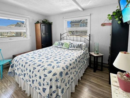a bedroom with a bed and two windows at Admiral's Quarters in Wells Beach