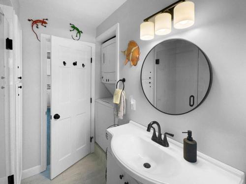 a white bathroom with a sink and a mirror at Admiral's Quarters in Wells Beach