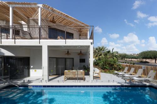 a villa with a swimming pool and a house at Ella Sun - Coconut Villa in Eilat