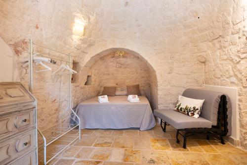 una camera da letto con un letto e una sedia in una stanza di Trulli Macco Macco a Lamie di Olimpia