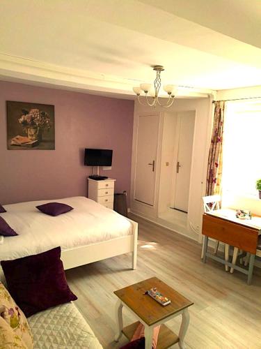 a bedroom with a bed and a couch and a table at Appartement Studio Le Clem's in Bayeux