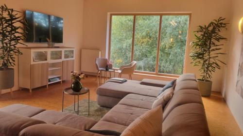 a living room with a couch and a large window at Ferienwohnung Stützenmühle in Haßfurt