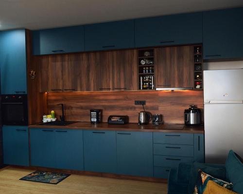 Izvorski Horizonti的厨房配有蓝色橱柜和白色冰箱