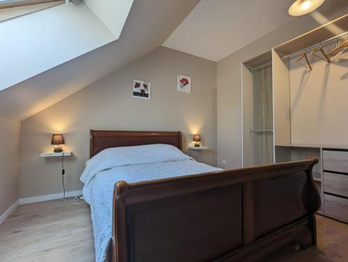 a bedroom with a bed and two lamps in a attic at Gite La Nobleterie - 4 personnes Zoo de Beauval 35min in Frédillé