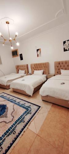 a room with three beds and a rug at شقة عائلية مودرن 4 غرف نوم رقم 1 in Quai