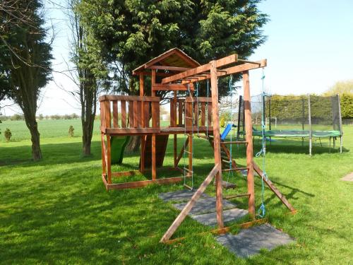 a playground with a wooden structure in the grass at Lambourne House - Ukc2831 in Winthorpe