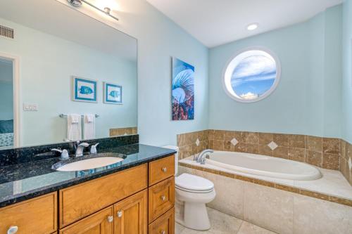 a bathroom with a tub and a toilet and a sink at Admirals Watch - 673 in Siesta Key