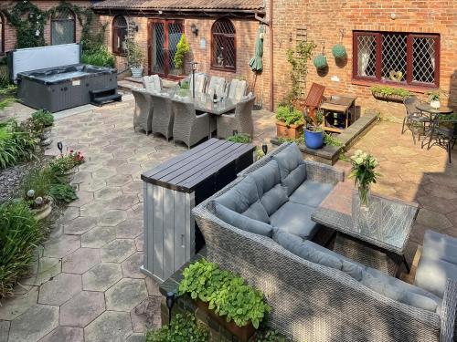 a patio with a couch and a table and a grill at Lambourne House - Ukc2831 in Winthorpe