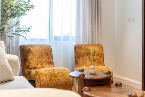 two chairs and a table in a living room at The Khorfakkan Suite by Riviera in Khor Fakkan