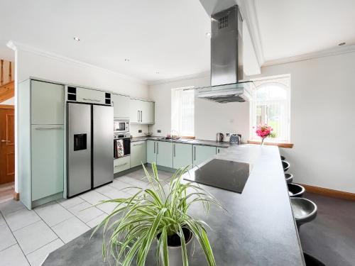 a kitchen with white appliances and a table with plants at Home Farm in Dunragit