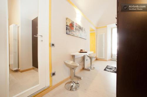 a bathroom with a table and two stools in a room at Charming Flat in Mondovì Piazza (CN) 70 m² + Balcony in Mondovì
