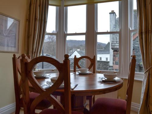 a dining room table with chairs and a large window at Causey Pike in Keswick