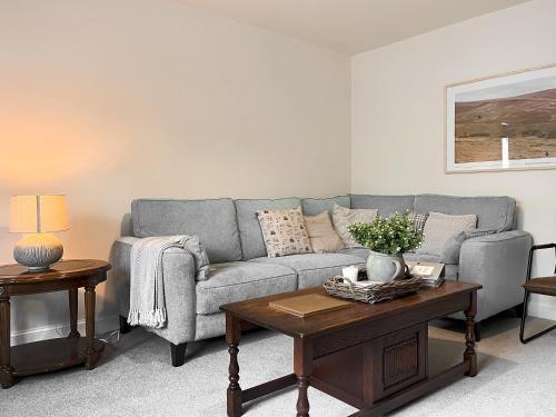 una sala de estar con un sofá y una mesa en Oakstone House, en Buxton