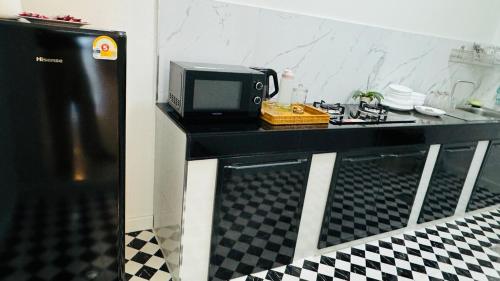 a microwave sitting on a counter in a kitchen at Chun Pa House in Sathani Khlong Rian