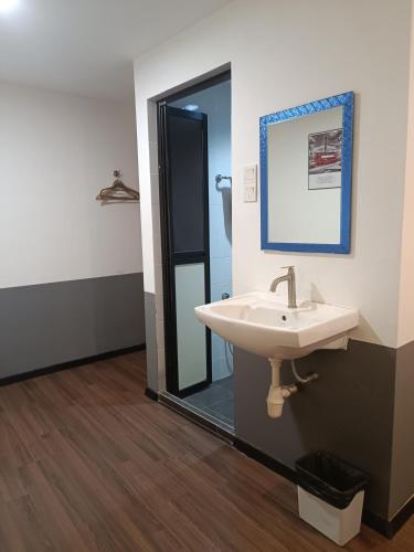 a bathroom with a sink and a mirror at SO Hotel in George Town