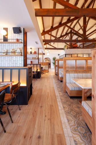 a restaurant with wooden floors and tables and chairs at Hostal Boutique - Rivolto Rooms in Santa Susanna