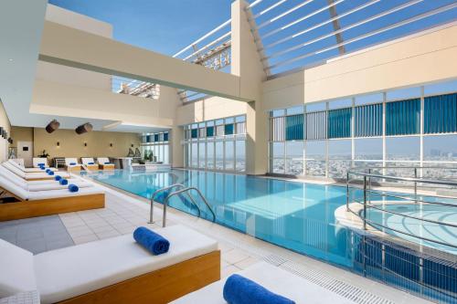 a pool in a building with a view at Grand Millennium Al Wahda Executive Apartments in Abu Dhabi