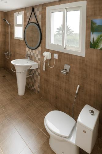 a bathroom with a toilet and a sink and a mirror at درة العروس فيلا الأحلام d in Jeddah