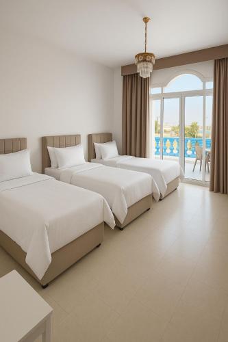 a row of beds in a room with a window at درة العروس فيلا الأحلام d in Jeddah
