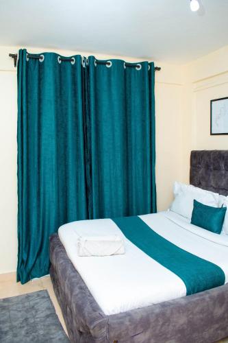 a bedroom with a large bed with a green curtain at SJ Homes in Eldoret