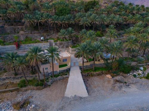 an aerial view of a house with palm trees at Hajir Garden House in Muşayna‘ah