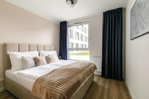 una camera da letto con un letto grande con una finestra di Zeitraum Raclawicka a Cracovia