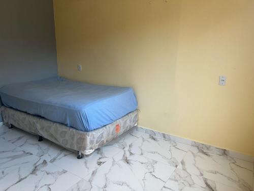 a bed sitting on top of a marble floor in a room at Lu Alter Residence in Santarém