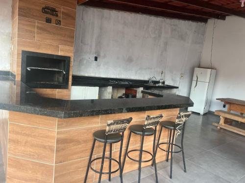 a kitchen with a counter with four bar stools at Lu Alter Residence in Santarém