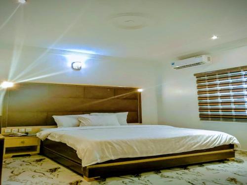 a bedroom with a large bed in a room at Victoria Garden Hotel & Fast Food Service in Onitsha