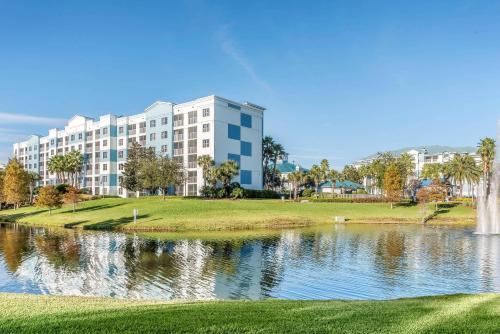 a building next to a lake with a fountain at Bluegreen Vacations Fountains, an Ascend Collection Resort in Orlando