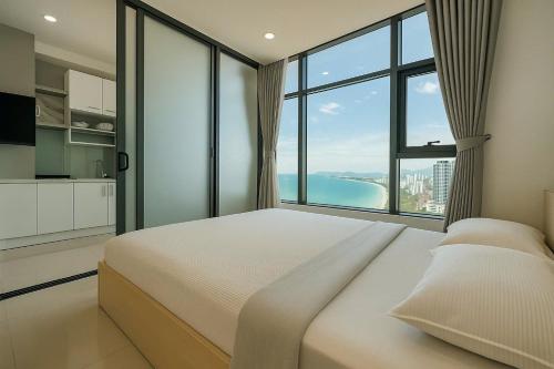 a bedroom with a large bed and a large window at Sunrise Sea View Apartment in Nha Trang