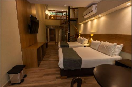 a hotel room with two beds and a television at Termales Santa Rosa De Cabal in Santa Rosa de Cabal