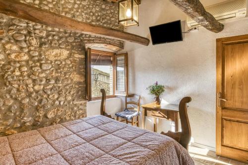 a bedroom with a bed and a table and a window at Can Roca in Montiró