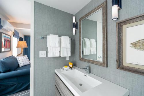 a bathroom with a large white tub and a mirror at Edgar Hotel Martha's Vineyard, an Ascend Collection Hotel in Edgartown
