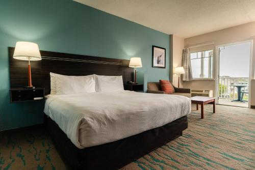 a hotel room with a large bed and a chair at Gateway Hotel & Suites, an Ascend Collection Hotel in Ocean City