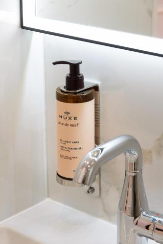 a bottle of nivea moisturizing liquid soap next to a sink at Les Suites Tour Eiffel in Paris