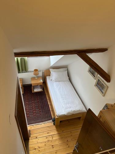 a small bedroom with a bed and a table at Guest House Anna Caffe in Bezdan