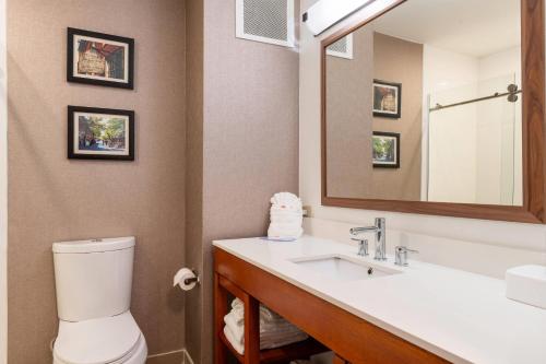 a bathroom with a toilet and a sink with a mirror at Comfort Inn Danvers - Boston North Shore in Danvers