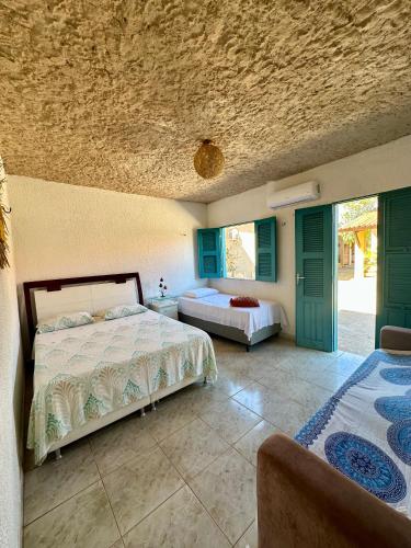 a bedroom with two beds in a room with a ceiling at Pousada Villa do Sol Taiba in Taíba