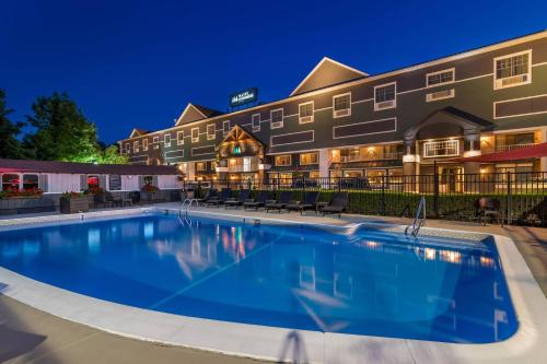 a large pool in front of a hotel at night at Maine Evergreen Hotel, an Ascend Collection Hotel in Augusta