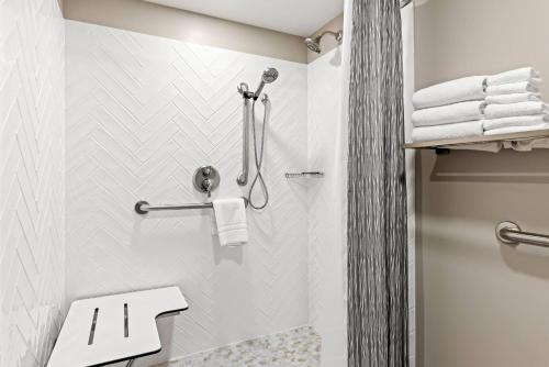 een badkamer met een douche, een toilet en handdoeken bij Lumber Jack Lodge, an Ascend Collection Hotel in West Branch