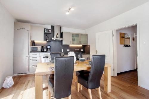 a kitchen with a wooden table and black chairs at sennefeeling in Hövelhof